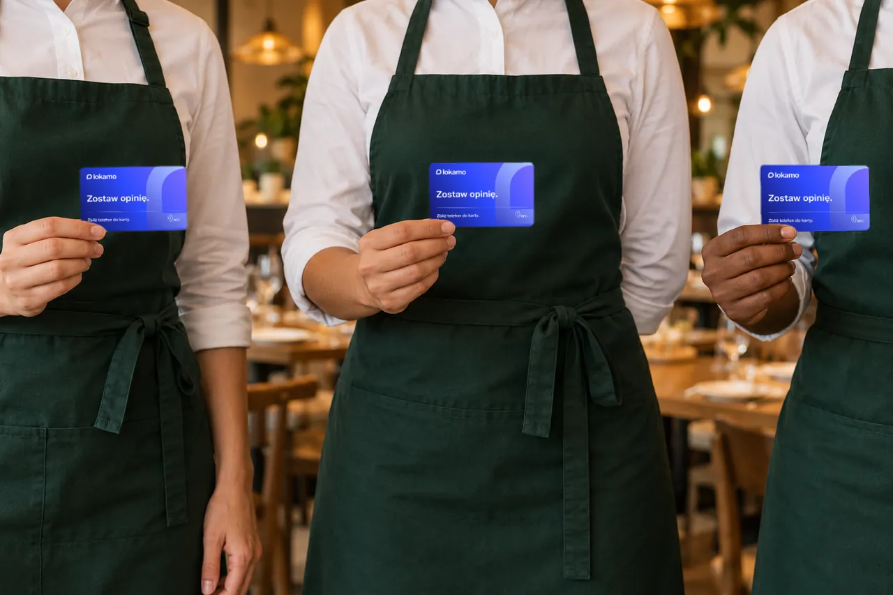 Troje pracowników restauracji w zielonych fartuchach trzyma karty NFC Lokamo Niebieska, bez twarzy w kadrze